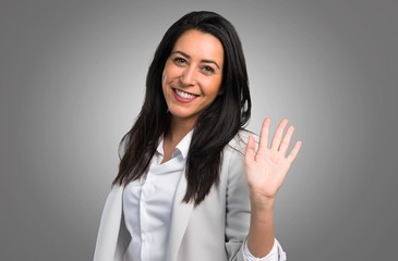 Pretty woman saluting on grey background