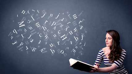 Wall Mural - Casual young woman holding book with white letters flying out of it