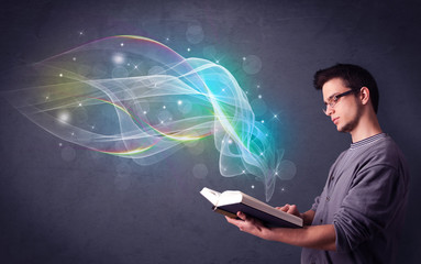 Poster - Casual young man holding book with rainbow waves flying out of it