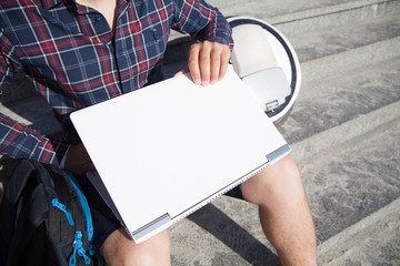  A businessman sitting on the street opens his laptop, beside is a mono wheel.