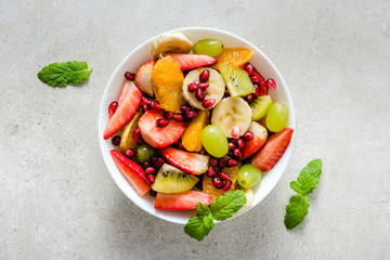 Wall Mural - Fresh fruit salad on bright background, healthy diet concept