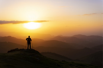 Man on top of mountain at sunset. Conceptual scene.