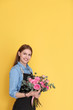 © New Africa - Female florist holding bouquet of beautiful flowers on color background