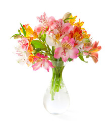 Wall Mural - Bouquet of colorful  Alstroemeria flowers in a transparent glass vase isolated on white background.