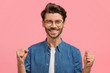 © WHstudio Leushin N - Glad male winner with cheerful expression, clenches fists in triumph, expresses his power and happiness, poses against pink background. Optimistic bearded man has happy look, gestures indoor