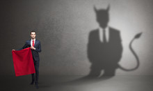 Businessman Standing With Red Cloth In His Hand And Devil Shadow On The Background
