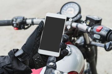 biker riding motorbike and holding smart phone