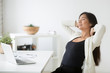 © fizkes - Relaxed happy asian woman enjoying break at workplace, calm smiling korean employee relaxing from computer holding hands behind head breathing air, positive thinking, feeling no stress free at work
