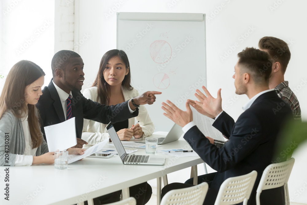 Diverse employees arguing during team meeting, african office worker ...