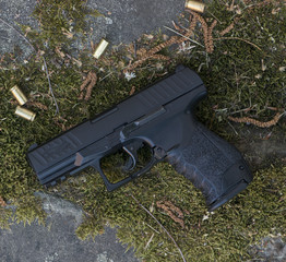 gun with a cartridge on the surface of a rusty metal sheet