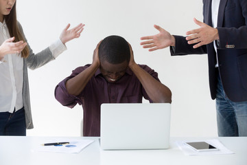 Angry overwhelmed african businessman frustrated with discrimination at work, hates stressful job, feels headache or closing ears to avoid annoying people noise, nervous breakdown or burnout concept