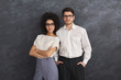 Confident business couple on gray background