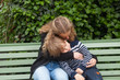 © Aitor Diago - Girl hugs her older brother while they doze sitting on a bench outdoors