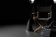 © aanbetta - Director Chair,Megaphone,Movie Clapper and lighting equipment on dark background.