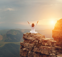 Wall Mural - woman practices yoga and meditates   on mountains .