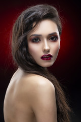 Wall Mural - Portrait of a beautiful glamorous brunette girl with naked shoulders. Shimmering makeup, red lips.