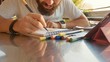 © alexeg84 - Male designer draw sketches in open air riverside cafe.