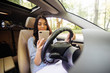 © F8  \ Suport Ukraine - Young woman using phone while driving her car