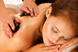 Stone therapy. Woman getting a hot stone massage at spa salon