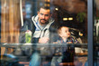 © AMR Studio - Portrait of father and son sitting in cafe shot through window glass. Father and son having fun together in a restaraunt. Hipster urban family
