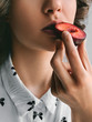 Fresh ripe plum Girl is eating a half of plum Close-up photo template with copy space