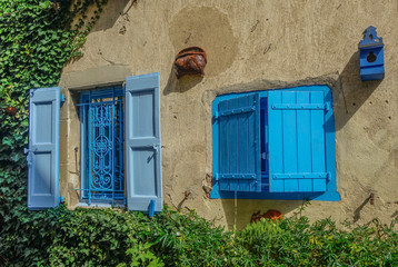 Revel, Midi Pyrenees, France - August 5, 2017: Two open blue rustic windows on a sunny day