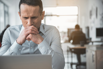 Portrait of dissatisfied male employer looking at gadget during job. Trouble at labor concept