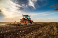 Tractor Cultivating Field At Spring