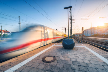 Wall Mural - white high speed train in motion on the railway station at sunset. germany. blurred modern intercity