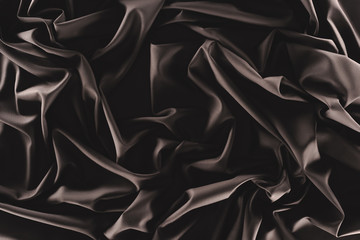 full frame of folded dark silk cloth as background