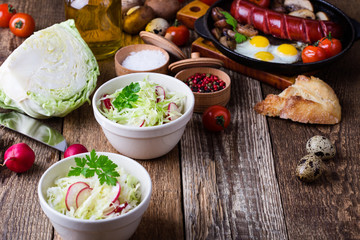 Wall Mural - Bowls of fresh vegetable salad with cabbage and radish