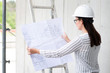Frau studiert Bauzeichnungen auf einer Baustelle 
