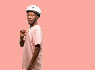 Poster - Black man wearing bike helmet proud, excited and arrogant, pointing with victory face