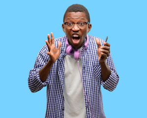 Poster - African black man student with smartphone stressful keeping hands on head, terrified in panic, shouting