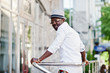 © AS Photo Family - Stylish african american man in white shirt and colored pants with hat and glasses posed outdoor. Black fashionable model boy.