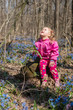 © lexmomot - Little girl is smelling flowers while sitting on green meadow