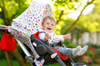 © Irina Schmidt - Cute little beautiful baby girl of 6 months sitting in the pram or stroller and waiting for mom