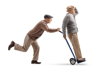 Canvas Print - Senior pushing a hand truck with another senior riding on it