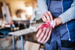 © Halfpoint - Man with an injured hand after accident at work in the carpentry workshop.