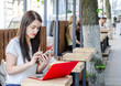 © Todayphoto - Beautiful brunette girl sits on bench at table in street cafe dials number on  phone