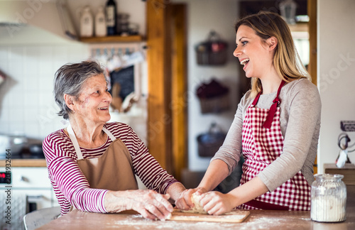 Fotografía An elderly grandmother with an adult granddaughter at home, baking