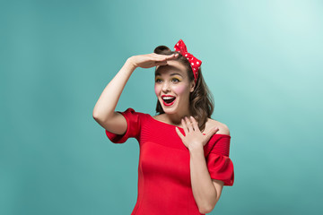 Wall Mural - Beautiful young woman with pinup make-up and hairstyle. Studio shot on white background