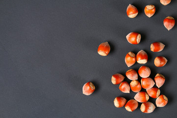 Wall Mural - Top view of roasted peeled hazelnuts on a saturated black background.Snacks. Top view. Copy space.