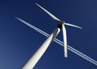 WIND TURBINE WITH JET AIRCRAFT EXHAUST TRAIL IN BLUE SKY