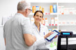 © Syda Productions - medicine, healthcare and technology concept - happy apothecary and senior male customer with digital prescription on tablet pc computer screen at pharmacy