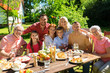 © Syda Productions - leisure, holidays and people concept - happy family having festive dinner or summer garden party