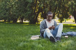© Prostock-studio - Young man listening to music on grass outdoors