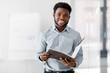 © Syda Productions - business, people and corporate concept - smiling african american businessman with folder at office