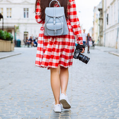 Wall Mural - woman walking by city with camera in her hand