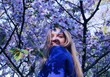 © Vladimir - beautiful smiling shy blonde woman in a blossoming garden, sakura garden in spring on a Sunny day
